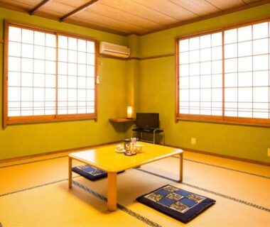 Traditional tatami room with low table, cushions and shoji screens at Koemon in Hyōgo
