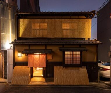 Traditional machiya entrance with noren at Kyōka auberge de Gion in Kyoto, warm evening street lighting