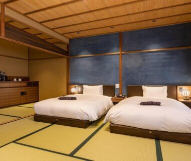 Tatami floor room with two low beds, shoji screens and wooden interior at Kyōka auberge de Gion, Kyoto