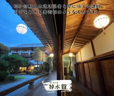 Covered wooden corridor overlooking manicured courtyard garden with hanging lanterns at dusk, Shinsuikan, Gunma, Kanto