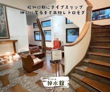 Curved wooden staircase in ryokan lobby with leather chairs and pebble floor, Shinsuikan, Gunma