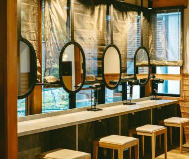 Long wooden vanity with round mirrors and stools at Kamikura Matsurube Onsen in Iwate