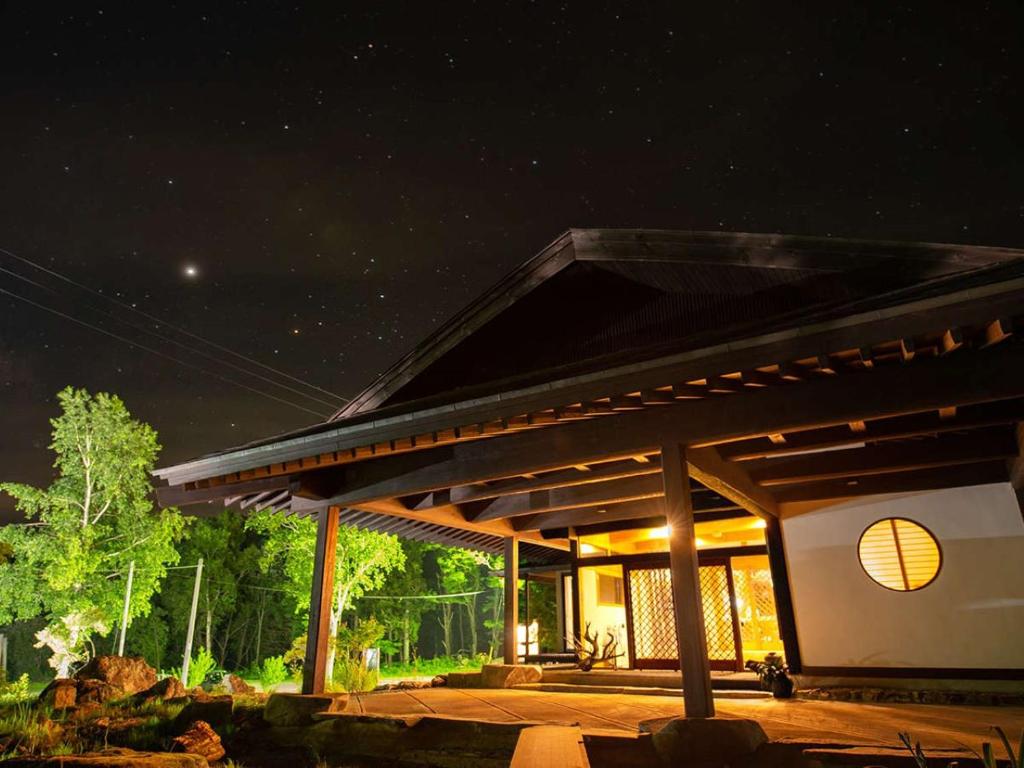 Starlit ryokan entrance Kamikura Matsurube Onsen Iwate Wooden entrance and lit interior under a starry sky at Kamikura, Matsurube Onsen, Iwate