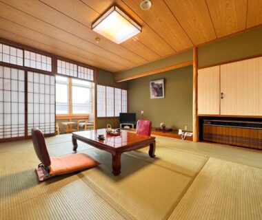 Tatami room with low table, zaisu chairs and shoji screens at Hitō Hanabun in Niigata