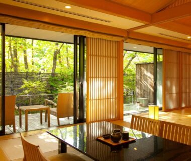 Tatami room with low table, shoji screens and garden view at Chikusenso Onsen Miyagi