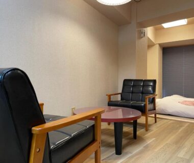 Wooden floor room with futon and black leather chairs at Zuihō-sō hébergement sans repas, Shizuoka, Chūbu