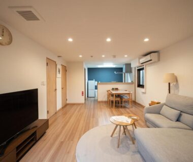 Bright living area with sofa, TV and dining nook at 素泊り旅館 Yururi in Ōita
