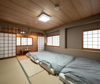 Traditional tatami room with three futon beds, shoji screens and wooden ceiling at 素泊り旅館 Yururi in Ōita Kyūshū