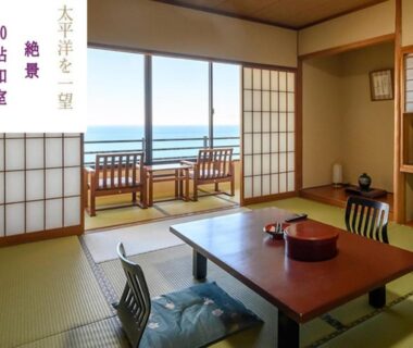 Japanese tatami room with low table, zabuton cushions, shoji screens and sea view at Shinpachiya in Mie