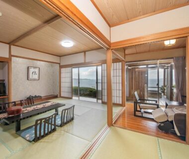 Traditional tatami room with low dining table and sliding doors opening to coastal view at Shinpachiya Mie prefecture