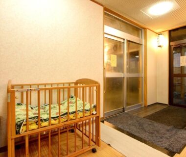 Wooden baby crib beside genkan entrance at Fukubikiya Hōraikan, Yomogihira Onsen, Niigata