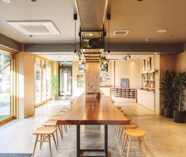 Long wooden communal table and stools at 蓼科BASE kitchen,spa&hotel lobby Nagano