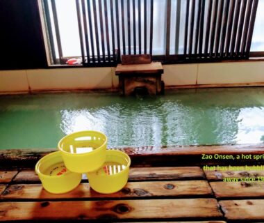 Indoor onsen bath with wooden edge and yellow washing stools Ringoya Zaō Onsen Yamagata