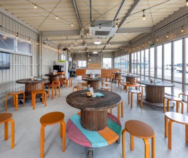 Open dining area with round spool tables and wooden stools at Isamiya, Fukushima Tōhoku