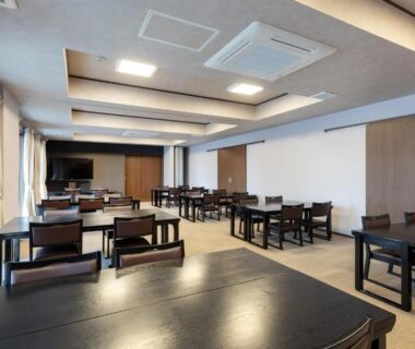 Spacious dining room with dark wooden tables and chairs, large windows, Isamiya, Fukushima, Tōhoku, Japan