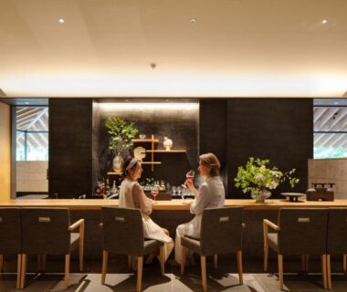 Guests seated at lounge counter with wooden chairs and plants at Nasu Muku no Ne, Tochigi