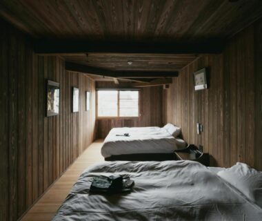 Wood-paneled sleeping room with futons and narrow windows at 酒蔵宿西山 鼓傳 in Hyōgo