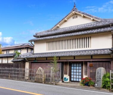 Exterior street view of traditional ryokan with tiled roof, wooden lattice facade and entrance in Hyōgo, Kansai