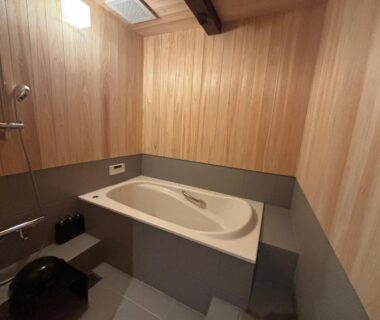Bathtub and shower in wood-paneled room at 酒蔵宿西山 鼓傳 -koden- Hyōgo Kansai