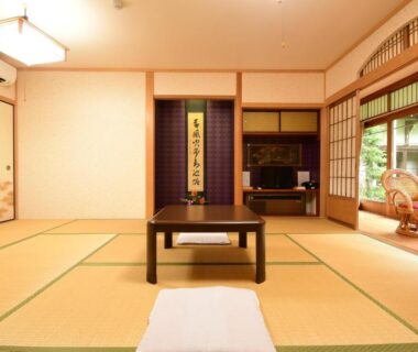 Traditional tatami room with low table, tokonoma scroll, shoji screens and garden-facing window at Kongo Sanmaiin Wakayama