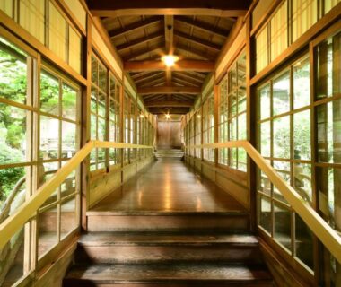 Long wooden corridor with floor-to-ceiling windows overlooking garden at Kongo Sanmaiin, Wakayama, Kansai, Japan