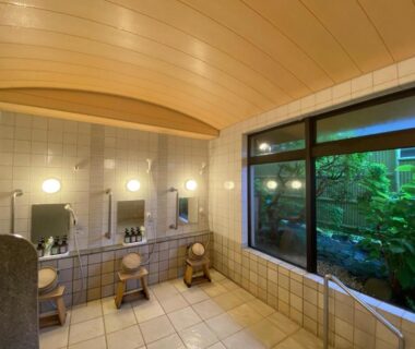 Tiled wash stations with stools, mirrors and soaking tub at 金閣莊 private onsen in Kanagawa