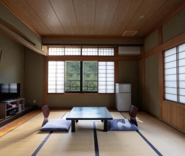 Traditional tatami room with low table, zabuton cushions and shoji screens at Zenigame in Ishikawa
