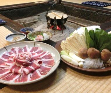 Thinly sliced meat and vegetables for hot pot beside a sunken hearth on tatami