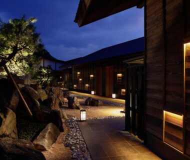 Night walkway with stone path, lanterns and wooden ryokan buildings at Sumihei Taiza Onsen, Kyoto
