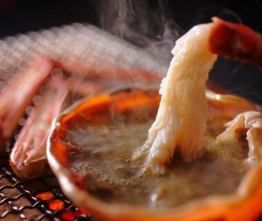 Grilled crab legs cooking in a small pot over coals at Sumihei in Taiza Onsen, Kyoto