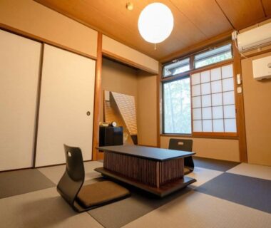 Tatami room with low table, zaisu chairs and shoji window at Abekura Onsen, Kanagawa