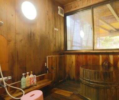 Wooden barrel tub and shower area at Suzumenoyado Yagura, Nagano