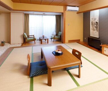Spacious tatami room with low table, cushions and seating area at Miyabitake in Kanagawa