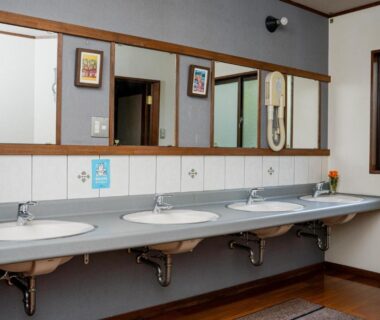 Row of washbasins with mirrors, tiled backsplash and hairdryer at Okara Sansō Nagano