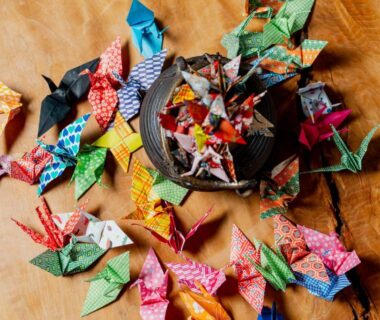 Colorful origami cranes on wooden table with woven basket at Okara Sansō, Nagano