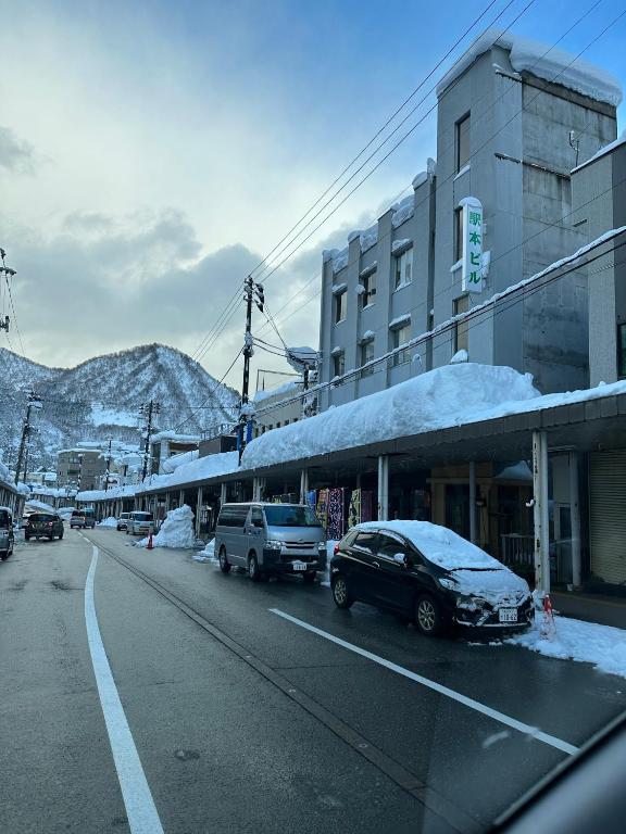 Snow covered street Hôtel Ekihon Building Niigata Street view with parked cars and snow-covered awnings at Hôtel Ekihon Building, Niigata, Chūbu