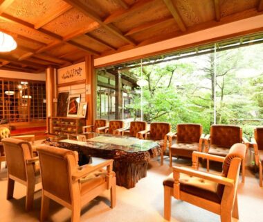 Sunlit wooden lounge with armchairs and garden view inside Koyasan Shukubo Sanboin in Wakayama
