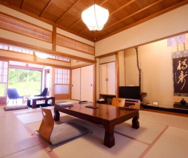 Tatami room with low wooden table, zabuton seating, shoji screens and garden view at Koyasan Shukubo Fudoin Wakayama