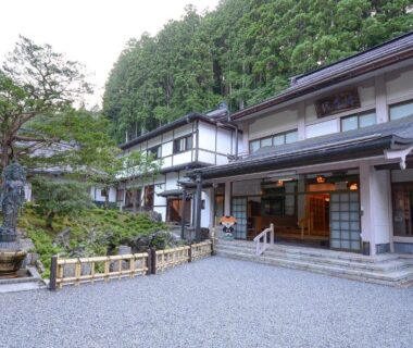 Gravel courtyard and stone lantern at Koyasan Shukubo Fudoin, Wakayama forested hillside backdrop