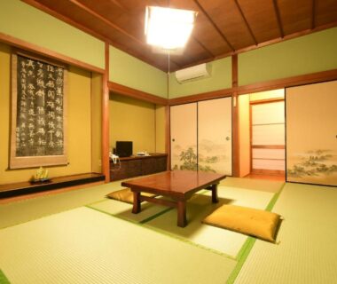 Tatami room with low table, zabuton cushions and painted fusuma at Koyasan Shukubo Daienin, Wakayama