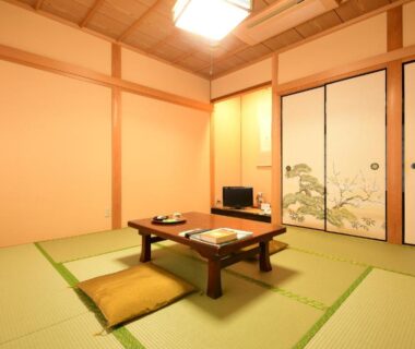 Traditional tatami room with low wooden table, zabuton cushions and painted fusuma at Koyasan Shukubo Daienin