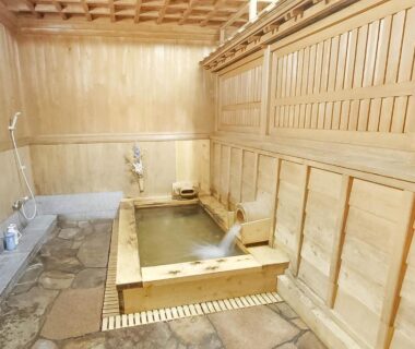 Wooden indoor bath with stone floor and shower area at Koyasan Shukubo Daimyououin, Wakayama