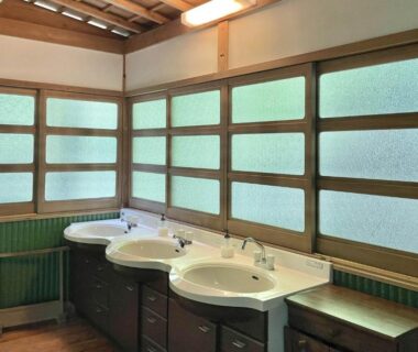 Communal washbasin with three sinks and frosted wooden windows at Koyasan Shukubo Hojoin in Wakayama