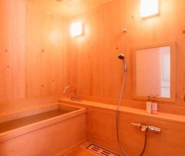 Wood-paneled bathing room with wooden tub and handheld shower at Koyasan Shukubo Fumonin, Wakayama
