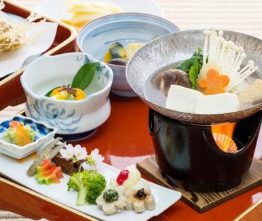 Multi-course Japanese meal on lacquer trays with tabletop hotpot and assorted small dishes at Koyasan shukubo Fumonin in Wakayama