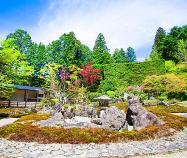 Stone rock garden with circular pathway, moss and trees beside a wooden pavilion at Koyasan Shukubo Sojiin, Wakayama