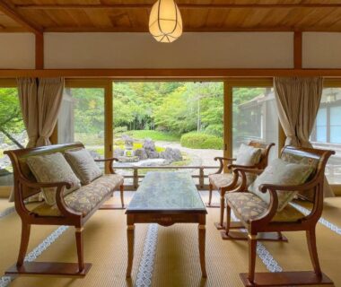 Tatami room with wooden armchairs and low table facing a garden at Koyasan Shukubo Sojiin, Wakayama