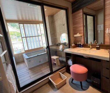 Vanity with sink and stool, sliding glass door to in-room bath at Yurara Marukyō, Kinugawa Onsen, Tochigi