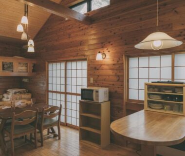 Interior dining space with wooden walls, shoji screens, dining table and chairs at Hôtel et cottages Kinasa no Yu, Nagano