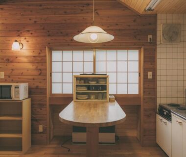 Wood-paneled kitchenette with dining table and shoji screens at Kinasa no Yu in Nagano, Chūbu, Japan